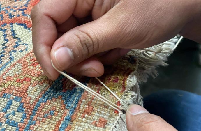 worker repairing flood damaged rug